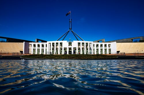 A photograph of Australian federal Parliament with a blue sky behind.