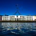 A photograph of Australian federal Parliament with a blue sky behind.